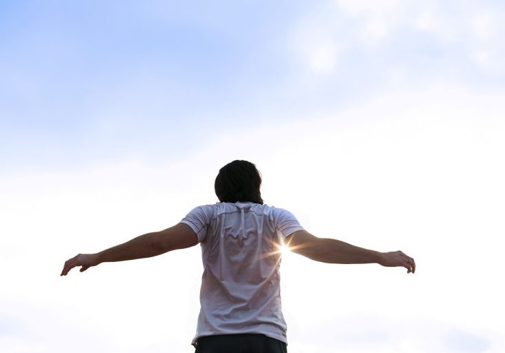 runner-stretching-arms-in-sun